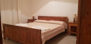 a bedroom with a wooden bed with two night stands at Residence Spiaggia Bianca in Golfo Aranci