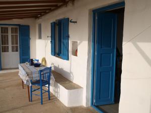 a blue chair sitting on a porch with a table at Alatsaria House in Cherronisos