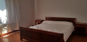 a bedroom with a bed with a wooden frame and a window at Residence Spiaggia Bianca in Golfo Aranci