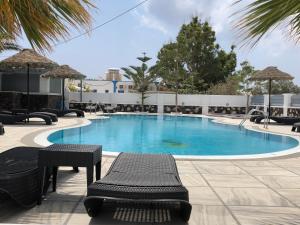 a large swimming pool with chairs and a table at Blackcoast Santorini in Perivolos