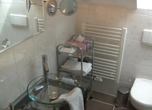 a bathroom with a glass table and a toilet at Gästehaus Baier am Bad in Bad Wiessee