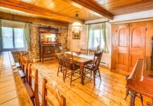 a dining room with a wooden table and chairs at Auberge Baker in Chateau Richer