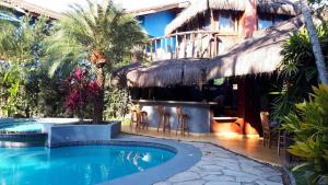 un complejo con piscina y bar en Pousada North Shore Maresias - 2 quadras da praia - Casas de 2 quartos - 80 m2 -2 banheiros -piscina sauna - estacion-churrasq privativa -wifi animais de peq porte roupa de cama e banho, en Maresias