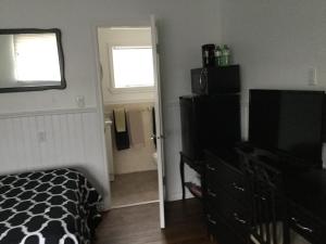 1 dormitorio con 1 cama y TV de pantalla plana en Bridgewaters Inn, en Johnstown