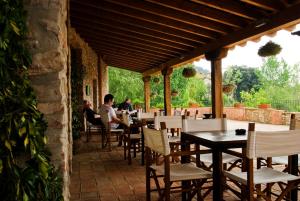 un restaurante con mesas y sillas en un patio en Hotel Moli De La Torre, en Bigues i Riells