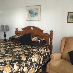 1 dormitorio con 1 cama y 1 silla en Bridgewaters Inn, en Johnstown