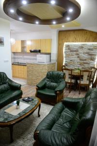 a living room with couches and a table and a kitchen at Apartments MM in Nik&scaron;ić