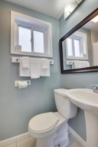 a bathroom with a toilet and a sink and a mirror at White Marlin Inn in Ocean City