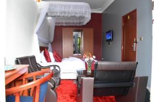 a hotel room with a bed and a table and chairs at Lebanon Hotel in Kigali