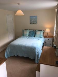 Y ベリンヘリにあるStunning House in Felinheli Marinaのベッドルーム(青い枕の大型ベッド1台付)