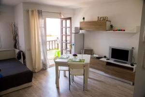 a small living room with a table and a television at Apartamento Casita Blanca in Corralejo