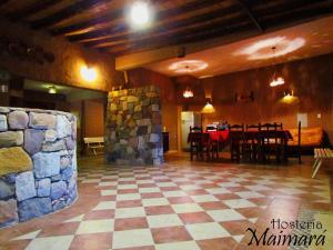 a large room with a stone wall and a table at Hosteria Maimará in Maimará