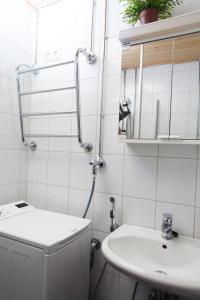 uma casa de banho branca com um lavatório e um espelho em Orchidea Kamppi em Helsínquia