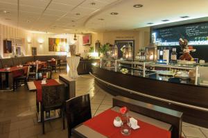 ein Restaurant mit Tischen und Stühlen und eine Bar in der Unterkunft Hotel & Restaurant 4 Winden in Windhagen