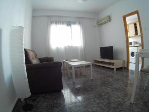 een woonkamer met een bank, een tafel en een televisie bij Benimaclet in Valencia