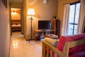 a living room with a couch and a television at Puerto Escondido in Santa Teresita
