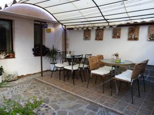 a patio with tables and chairs in a building at Guest House Plavas in Sozopol