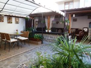 a patio with a table and chairs and plants at Guest House Plavas in Sozopol
