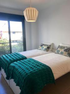 a bedroom with two beds and a large window at Diamond Beach 2 in Burriana