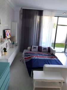 a bedroom with a bed and a large window at ZEV- Cataleya Mamaia Nord in Mamaia Sat/Năvodari