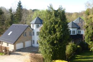 a large white house with a garage at Ferienwohnung am Eifelsteig in Roetgen