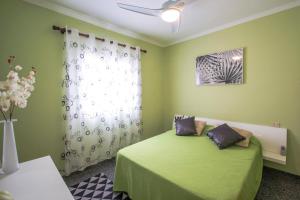 um quarto verde com uma cama e uma janela em Ricky em Arrecife