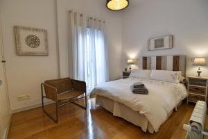 1 dormitorio con 1 cama grande y 1 silla en Apt. El Escondite, Centro Histórico, en Málaga