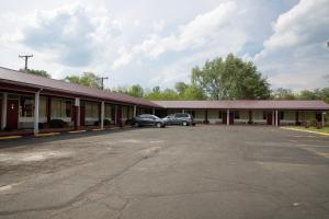 a building with two cars parked in a parking lot at Highlander Motel in Athens
