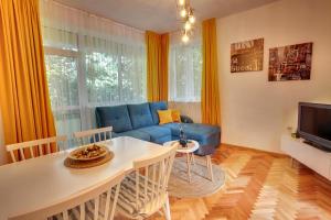 uma sala de estar com um sofá azul e uma mesa em TERRACE HOME - Three bedrooms City center em Plovdiv