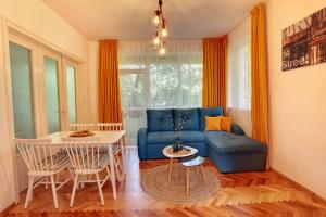uma sala de estar com um sofá azul e uma mesa em TERRACE HOME - Three bedrooms City center em Plovdiv