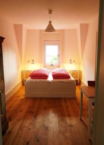 a bedroom with a bed with two red pillows and a window at Adventure Hostel Interlaken in Interlaken