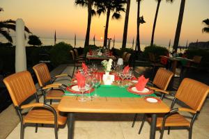 a table with chairs and a table with wine glasses at Fame Residence Kemer & Spa in Kemer