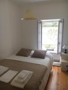 a bedroom with a large bed and a window at Cantinho da Matriz in Viana do Castelo