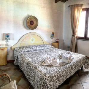 a bedroom with a bed with two towels on it at Il Dolce Risveglio Tanca Piras in Nebida
