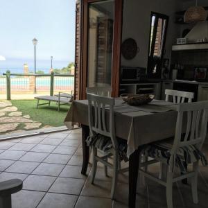a dining room table with chairs and a view of the ocean at Il Dolce Risveglio Tanca Piras in Nebida