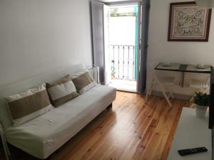 a living room with a white couch and a window at Cantinho da Matriz in Viana do Castelo