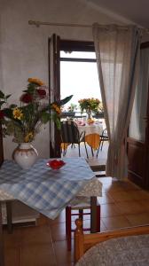 una sala de estar con una mesa con un jarrón de flores en Bed and Breakfast Due Leoni, en Torri del Benaco