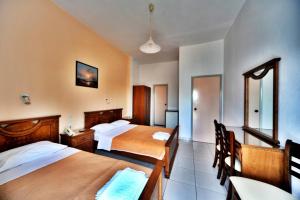 una camera d'albergo con due letti e un tavolo con sedie di Hotel Jason a Volos