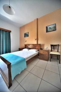 a bedroom with a bed and a desk and a chair at Hotel Jason in Volos