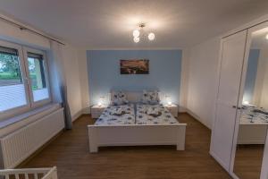 a bedroom with a bed and two windows and two tables at Ferienwohnung "Turmblick" in Rathmannsdorf