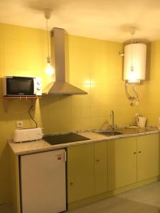 a kitchen with a sink and a microwave at Cantinho da Matriz in Viana do Castelo