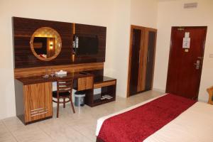 a bedroom with a bed and a dresser at Grand Nova Hotel in Dubai