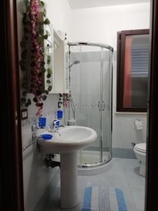 a bathroom with a sink and a glass shower at Villetta singola "Lilla" in Alì Terme