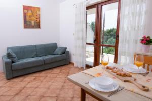 a living room with a couch and a table with wine glasses at Apartmani MIRA in Premantura