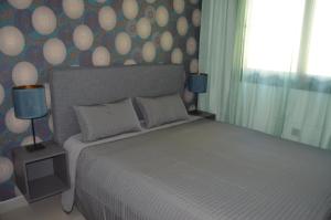 Un dormitorio con una cama grande y una pared con lunares. en Sunset Drive Exclusive - Benidorm, en Benidorm 36 fotos más