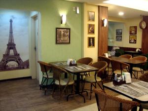 a restaurant with tables and chairs and the eiffel tower at London House in São José
