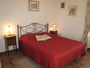 a bedroom with a red bed with two night stands at Chambre d'hôtes La Cour in Rauville-la-Place