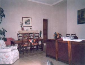 a living room with a table and a dining room at Chambre d'hôtes La Cour in Rauville-la-Place