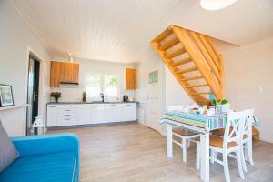 a kitchen and dining room with a table and stairs at Domki Całoroczne KLIF Ustka in Ustka