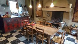 uma cozinha com uma mesa de madeira com cadeiras e um fogão em La belle endormie em Cabrerolles